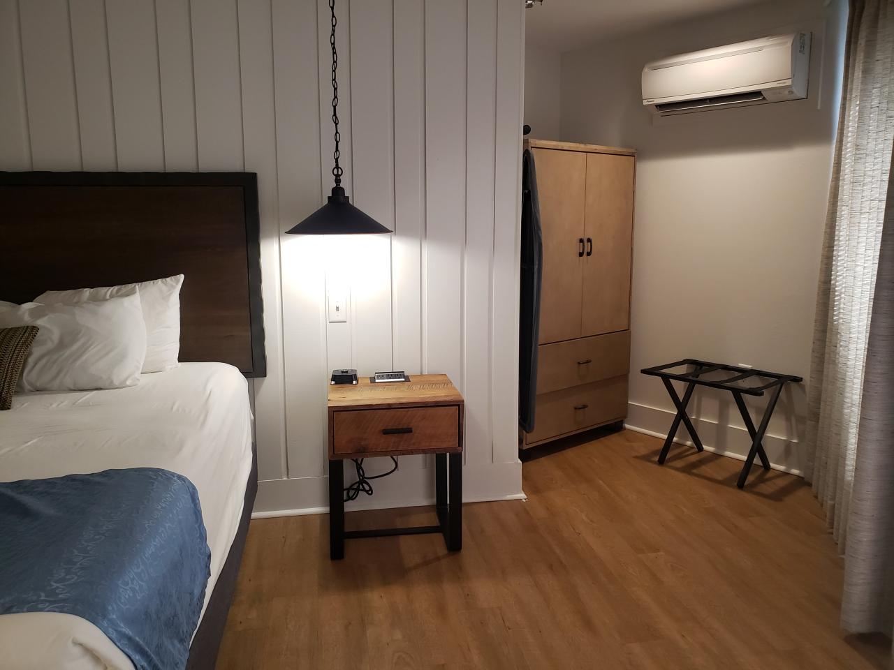 A view of the king bed and clothing storage area in the King Deluxe Suite at the Ozark Folk Center State Park